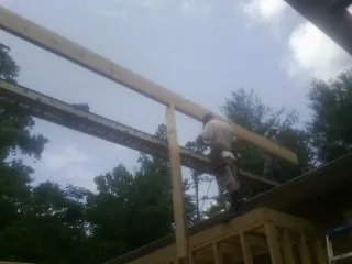 Carpenter setting a ridge beam over a new addition frame — Ice Dam Removal by Roofing Brothers in Highland Lakes