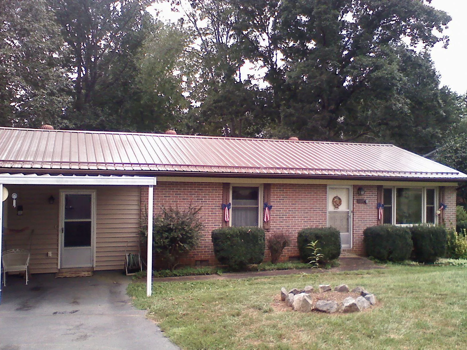 Bronze metal roof and carport on a brick ranch home — Roof Repair work by our crew in Highland Lakes
