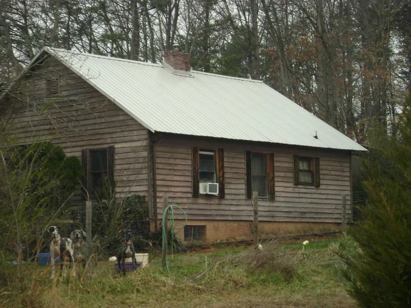 White metal roof on an old wood sided farmhouse, from a Metal Roof Installation job in Highland Lakes